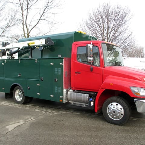 Green and Red Custom Lube Truck Bodies with Palfinger Crane attachment and side compartments for hose reels